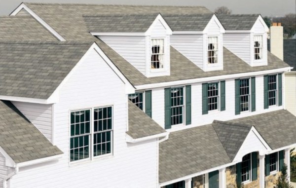 White home with grey roof and green shutters.